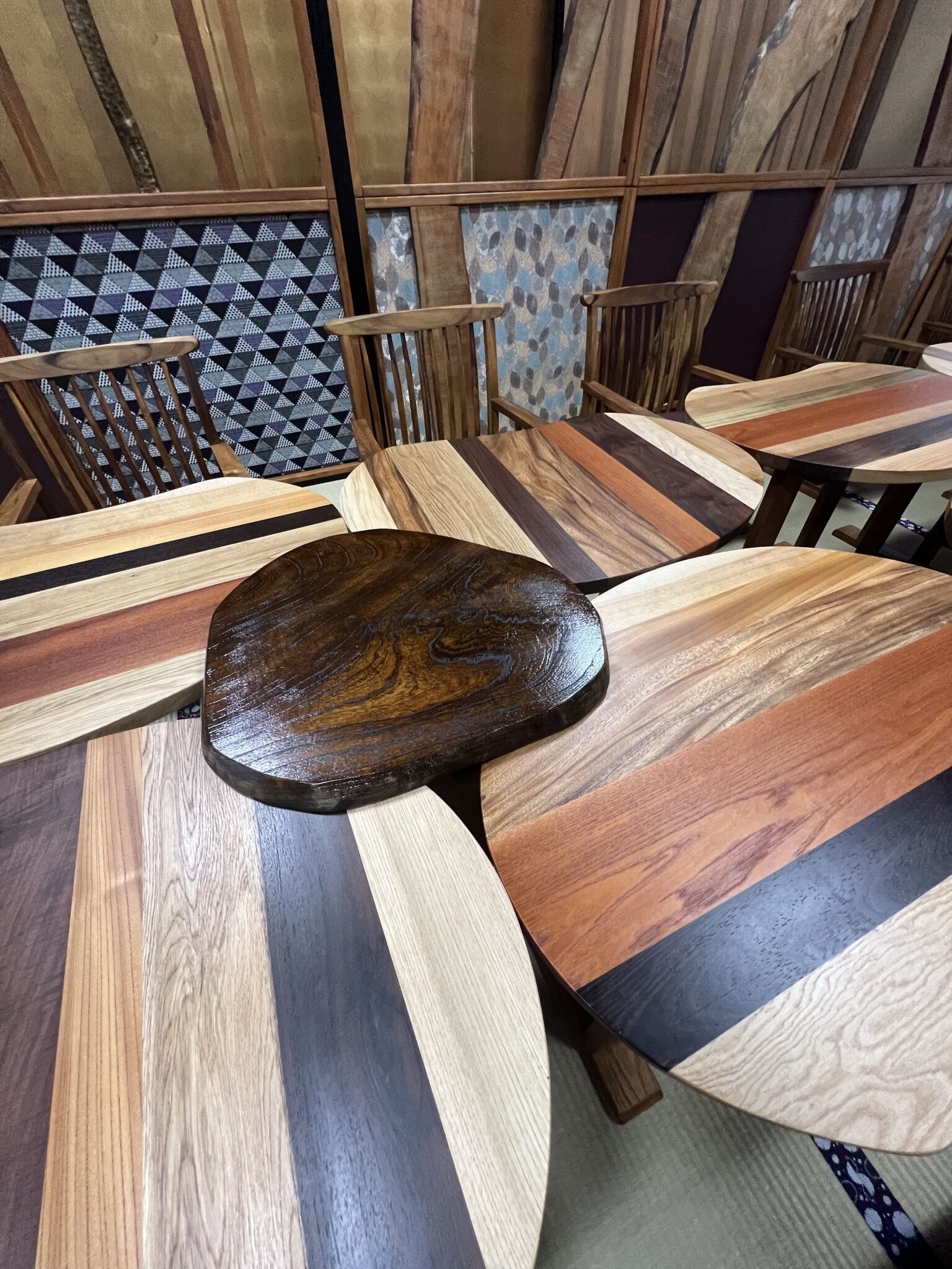 テーブルとテーブルの間には、欅の板も。テーブルに使われている欅に比べ、塗装を施して渋い色味になっています。